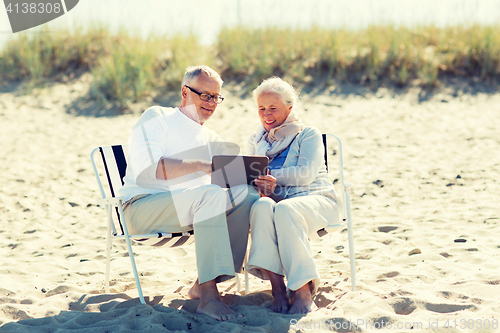 Image of happy senior couple with tablet pc on summer beach