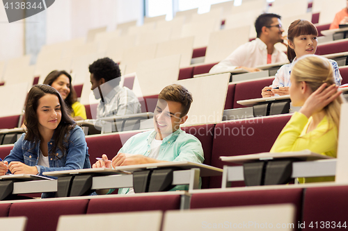 Image of group of students with notebooks in lecture hall