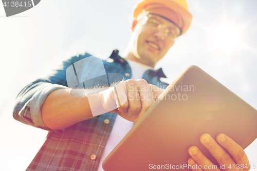 Image of close up of builder in hardhat with tablet pc