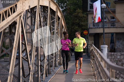 Image of multiethnic couple jogging in the city