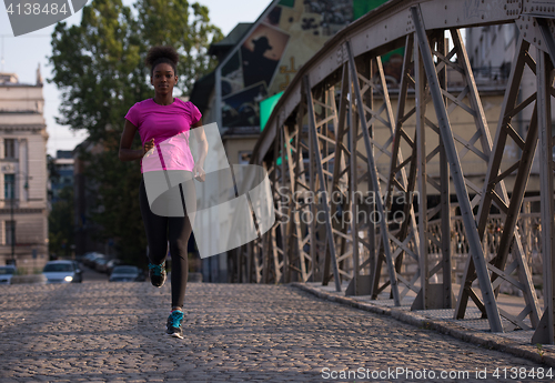 Image of african american woman running across the bridge