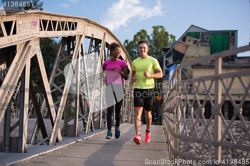 Image of multiethnic couple jogging in the city
