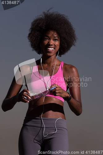 Image of african american woman jogging in nature