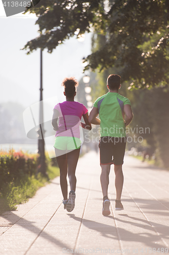 Image of young multiethnic couple jogging in the city