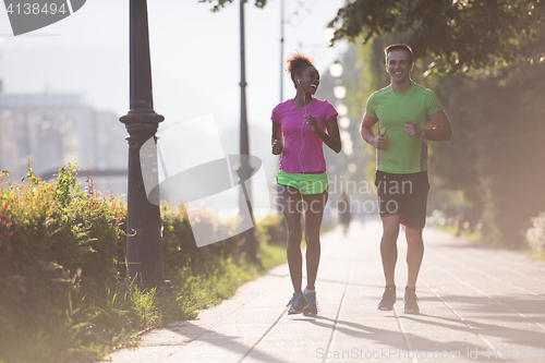 Image of young multiethnic couple jogging in the city