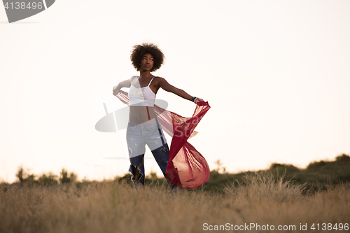 Image of black girl dances outdoors in a meadow