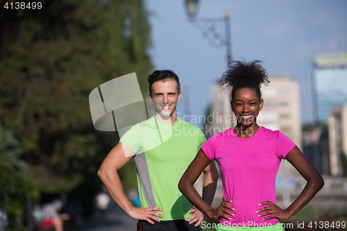 Image of portrait of young multietnic jogging couple ready to run