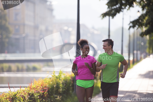 Image of young multiethnic couple jogging in the city