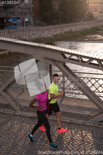 Image of young multiethnic couple jogging in the city