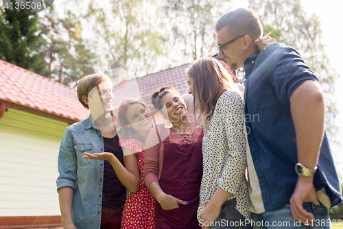 Image of happy teenage friends talking at summer garden