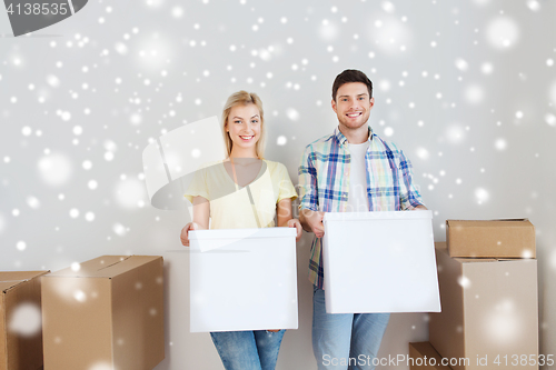 Image of smiling couple with big boxes moving to new home