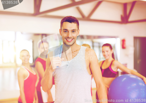 Image of smiling man standing in front of the group in gym