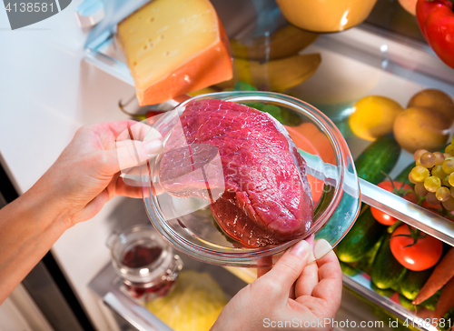 Image of Fresh raw meat on a shelf open refrigerator