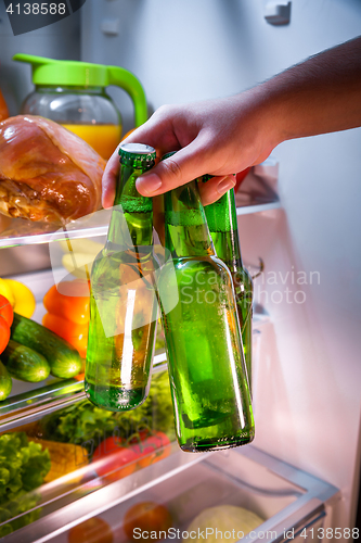 Image of Man taking beer from a fridge