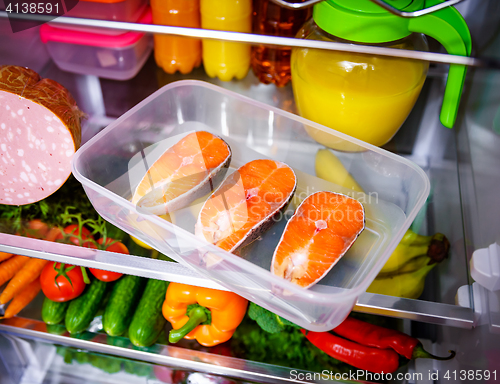 Image of Raw Salmon steak in the open refrigerator