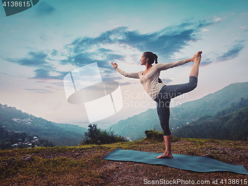 Image of Woman doing yoga asana Natarajasana outdoors on sunset