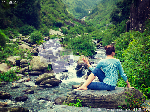 Image of Woman doing Ardha matsyendrasana asana outdoors