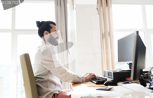 Image of happy creative male office worker with computer