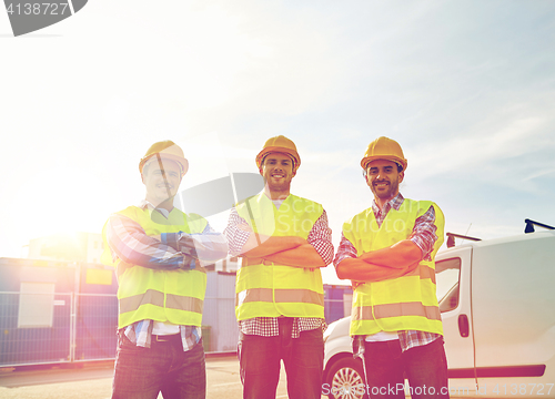 Image of happy male builders in high visible vests outdoors