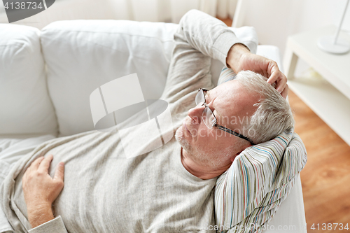 Image of close up of senior man in glasses thinking at home