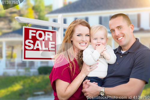 Image of Young Military Family in Front of For Sale Sign and House