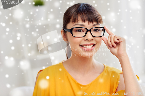 Image of happy asian young woman in glasses at home