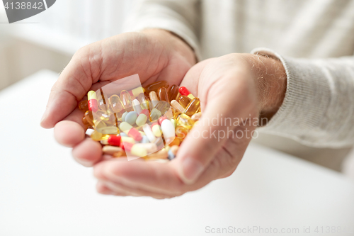 Image of close up of old man hands holding medicine