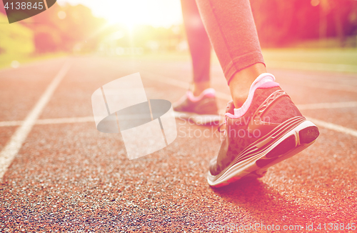 Image of close up of woman feet running on track from back