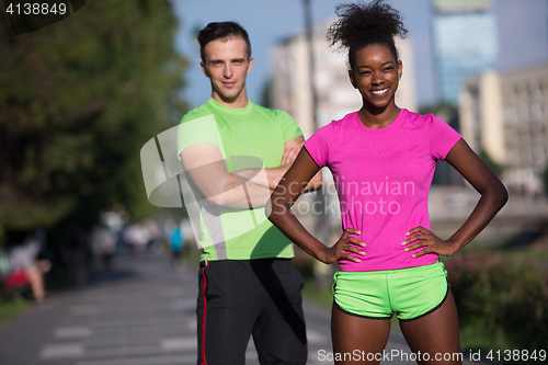 Image of portrait of young multietnic jogging couple ready to run