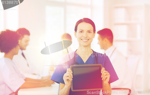 Image of happy doctor over group of medics at hospital