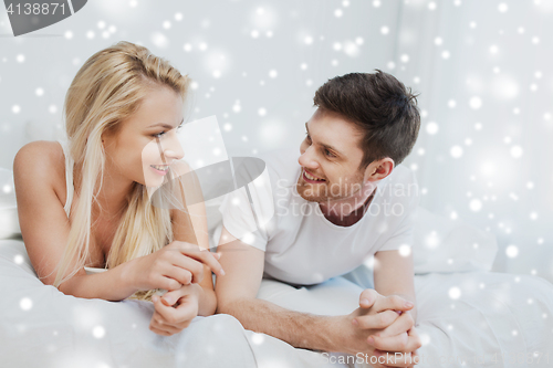 Image of happy couple lying in bed at home