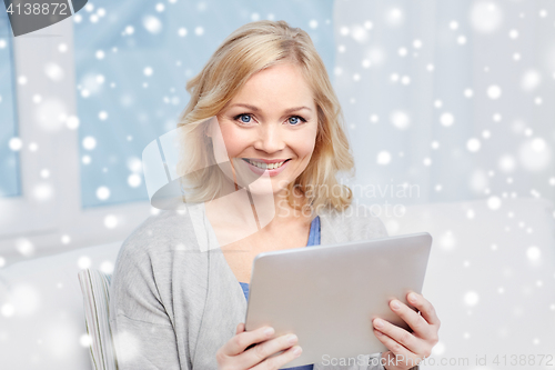 Image of happy middle aged woman with tablet pc at home