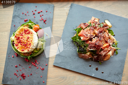 Image of goat cheese and ham salads on stone plates