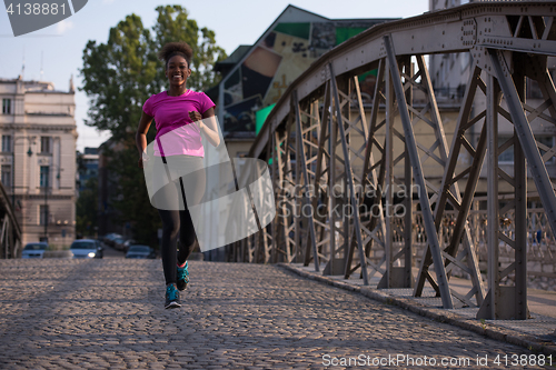 Image of african american woman running across the bridge