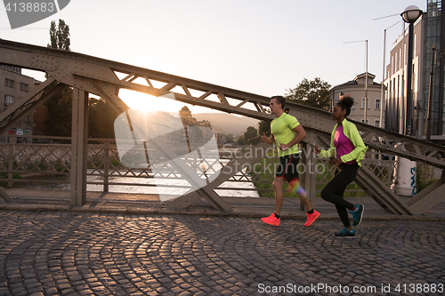 Image of young multiethnic couple jogging in the city