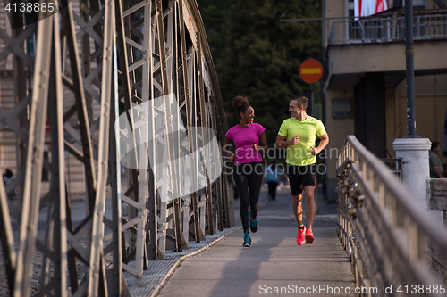 Image of multiethnic couple jogging in the city