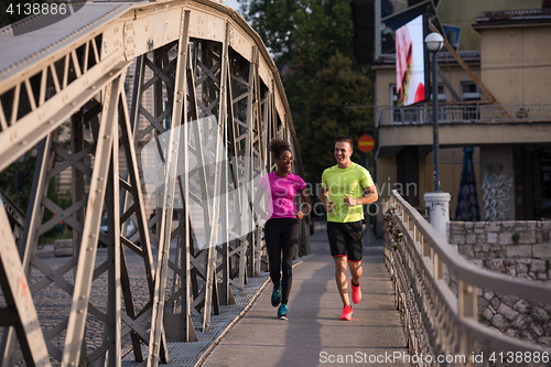 Image of multiethnic couple jogging in the city