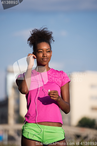 Image of young african american woman running outdoors