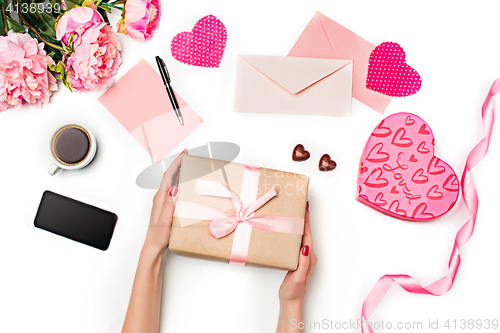 Image of The female hands with gift box on white background