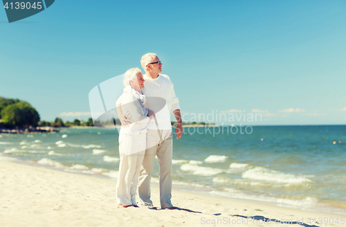 Image of happy senior couple hugging on summer beach