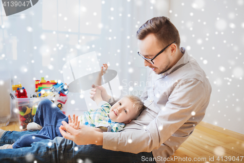 Image of father with son playing and having fun at home