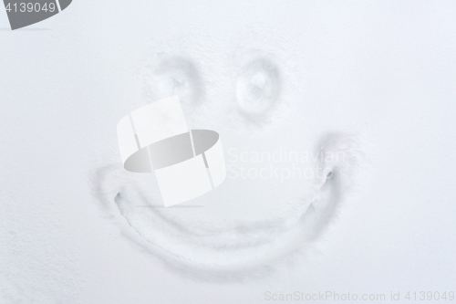 Image of smiley drawing on snow surface