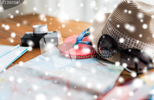 Image of close up of travel map, flip-flops, hat and camera