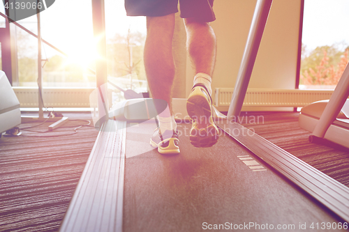 Image of close up of man legs walking on treadmill in gym