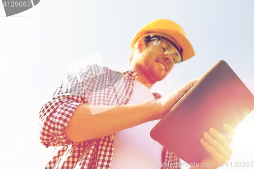 Image of close up of builder in hardhat with tablet pc