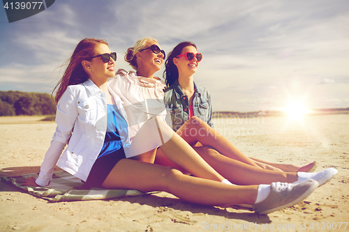 Image of group of smiling women in sunglasses on beach