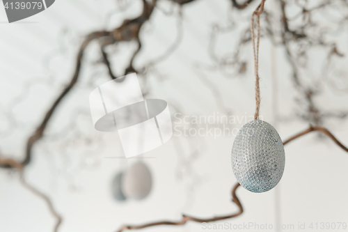 Image of Decorative easter eggs hanging from a twig