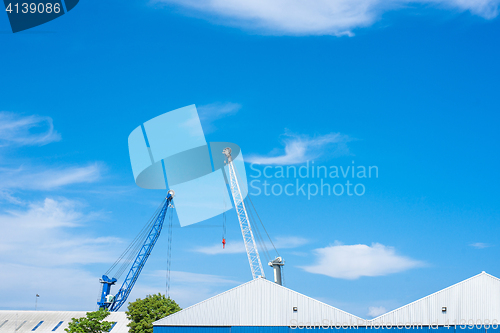 Image of Blue and white cranes at a storage building