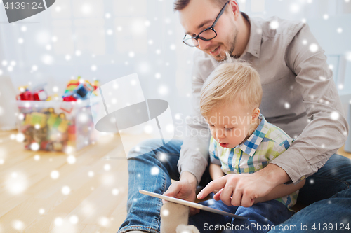 Image of father and son with tablet pc playing at home