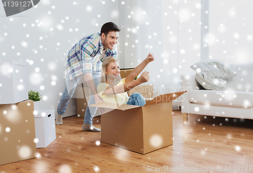 Image of happy couple having fun with boxes at new home